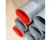 A close-up view of several gray pipes with red interiors, stacked together. Produktbild-Vorschau