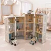 A wooden dollhouse with police and fire station themes, set up on a rug with toy cars and a helicopter. Anteprima dell’immagine prodotto
