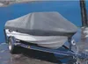 A boat covered with a gray tarp is on a trailer next to a body of water. Produktbild-Vorschau