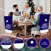 A family is gathered around a dining table, enjoying a Christmas meal. The chairs are decorated with blue Santa hat-shaped covers. Produktbild-Vorschau