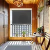 A balcony with wooden walls and floor, featuring a grey roller blind, a small wooden table and chairs, and potted plants. Náhled obrázku produktu