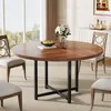 A round dining table with chairs in a well-lit room with a large window. Produktbild-Vorschau