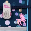 A close-up of a dark blue backpack with a polka dot pattern, featuring a pink unicorn keychain and a gray electronic device with the brand name 'McNeill'. Voir les images du produit