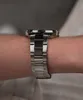 A close-up side view of a man's wrist wearing a silver metal watch. Náhled obrázku produktu