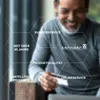 A man is smiling while holding a credit card and looking at a laptop, with hexagonal overlays containing text about the company's services and history. Produktbild-Vorschau