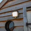A close-up shot of an outdoor light fixture mounted on a wooden wall. Anteprima dell’immagine prodotto