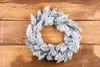 A frosted wreath is laid on a wooden surface. Anteprima dell’immagine prodotto