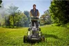 A man is mowing a lawn with a cordless lawnmower. Produktbild-Vorschau