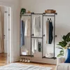 A wall-mounted garment rack with shelves in a room with a door and a chair. Produktbild-Vorschau