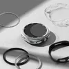 A collection of watch accessories, including screen protectors and protective cases, arranged on a light gray surface with dramatic shadows. Produktbild-Vorschau