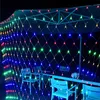 A net of colorful lights is draped over an outdoor seating area at night. Produktbild-Vorschau