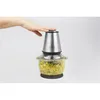 A hand is pressing down on the lid of a food chopper filled with chopped ingredients. Produktbild-Vorschau