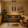A cozy living room scene with a sofa, coffee table, rocking chair, and a pendant light fixture. Náhled obrázku produktu