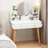 A white vanity table with a round mirror and wooden legs, set up in a bedroom next to a bed. Anteprima dell’immagine prodotto