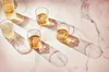 Several glasses of whiskey with ice cubes on a marble surface, with dramatic lighting and shadows. Anteprima dell’immagine prodotto