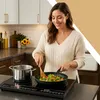 A woman is cooking in a modern kitchen. Voir les images du produit