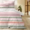 A bed with striped bedding in a room. Produktbild-Vorschau