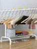 A white metal coat rack with clothes on hangers and folded clothes on a shelf below. Náhled obrázku produktu