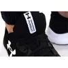 A close-up shot of a person wearing a black Under Armour Charged Pursuit 3 sneaker. Produktbild-Vorschau