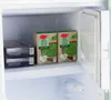 The image shows the inside of a refrigerator with two boxes of frozen peas and two boxes of aubergine gratin on the shelves. Produktbild-Vorschau