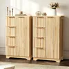 Two wooden cabinets with fluted doors and drawers are placed side-by-side in a room. Decorative items are on top of the cabinets. Náhled obrázku produktu