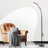 A modern black LED floor lamp illuminates a brown leather armchair with a gray blanket and pillow. Produktbild-Vorschau