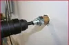 A drill bit is drilling a hole in a white wall. Podgląd zdjęcia produktu