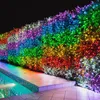 A hedge decorated with rainbow-colored LED lights next to a swimming pool at night. Náhled obrázku produktu