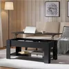 A black lift-top coffee table with a laptop and mug on its surface is shown in a living room setting. Produktbild-Vorschau