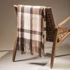 A plaid blanket draped over the back of a chair. Náhled obrázku produktu
