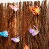 Decorative butterflies attached to a rustic fence. Produktbild-Vorschau