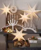 A festive Christmas display with illuminated paper stars, candles, and wrapped gifts. Podgląd zdjęcia produktu