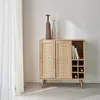 A wooden cabinet with rattan doors and a wine rack is displayed against a white wall with a sheer curtain on the left. Anteprima dell’immagine prodotto