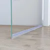 Close-up of the bottom edge of a shower door and a shower seal on a wooden floor. Produktbild-Vorschau