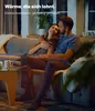 A couple is relaxing on a couch in a dimly lit living room. Produktbild-Vorschau