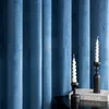Two white spiral candles in black candle holders are placed on a black surface in front of blue velvet curtains. Produktbild-Vorschau