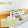 A collection of plastic freezer containers with green lids, some filled with frozen berries and peas, displayed on a light gray surface against a textured background. Produktbild-Vorschau
