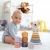 A baby is playing with stacking toys in a nursery. Voir les images du produit