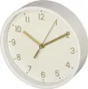 A close-up, angled view of a white Hama table clock with a cream-colored face and gold hands and numbers. Podgląd zdjęcia produktu