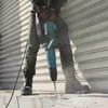 A person is using a demolition hammer to break concrete. Anteprima dell’immagine prodotto