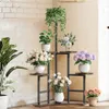 A multi-tiered plant stand filled with various potted plants and floral arrangements, set against a white brick wall. Náhľad obrázku produktu