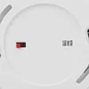 Close-up view of the back of a white smoke detector, showing a small red and black connector and a label with German text. Produktbild-Vorschau