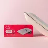 A pillow and its packaging are displayed against a pink background. Produktbild-Vorschau