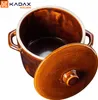 A brown ceramic pot with its lid slightly ajar, set against a white background. The pot has two side handles and a glossy finish. A logo and text are visible in the top left corner. Produktbild-Vorschau