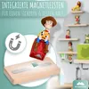 A toy figure is shown magnetically attached to a wooden shelf, with other figures on shelves in the background. Produktbild-Vorschau