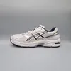 A side view of a white and navy blue Asics athletic shoe against a plain gray background. Produktbild-Vorschau