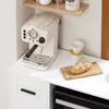 A kitchen scene with an espresso machine, coffee pour-over, and bread on a cutting board. Anteprima dell’immagine prodotto