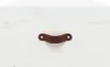 A close-up view of a brown leather handle attached to a white wooden surface. Náhľad obrázku produktu