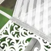 A close-up view of a white decorative panel with intricate cutouts, adorned with a silver band of rhinestones, attached to a white sheer curtain with vertical stripes. Náhľad obrázku produktu