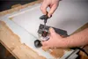 A person is using a router tool on a wooden frame. Anteprima dell’immagine prodotto